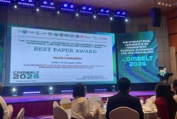 Uczestnicy gali ComBELT 2026 oglądają na ekranie nagrodę Best Paper Award przyznaną Maciejowi Szmigiero.