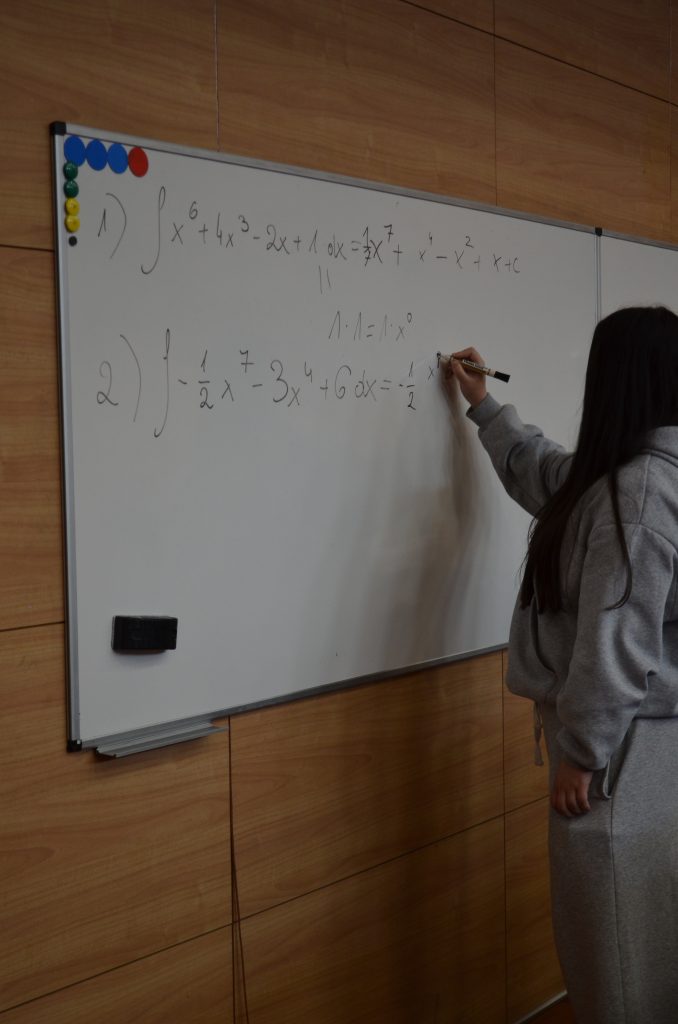 uczennica LO przy tablicy rozwiązujący zadania z matematyki