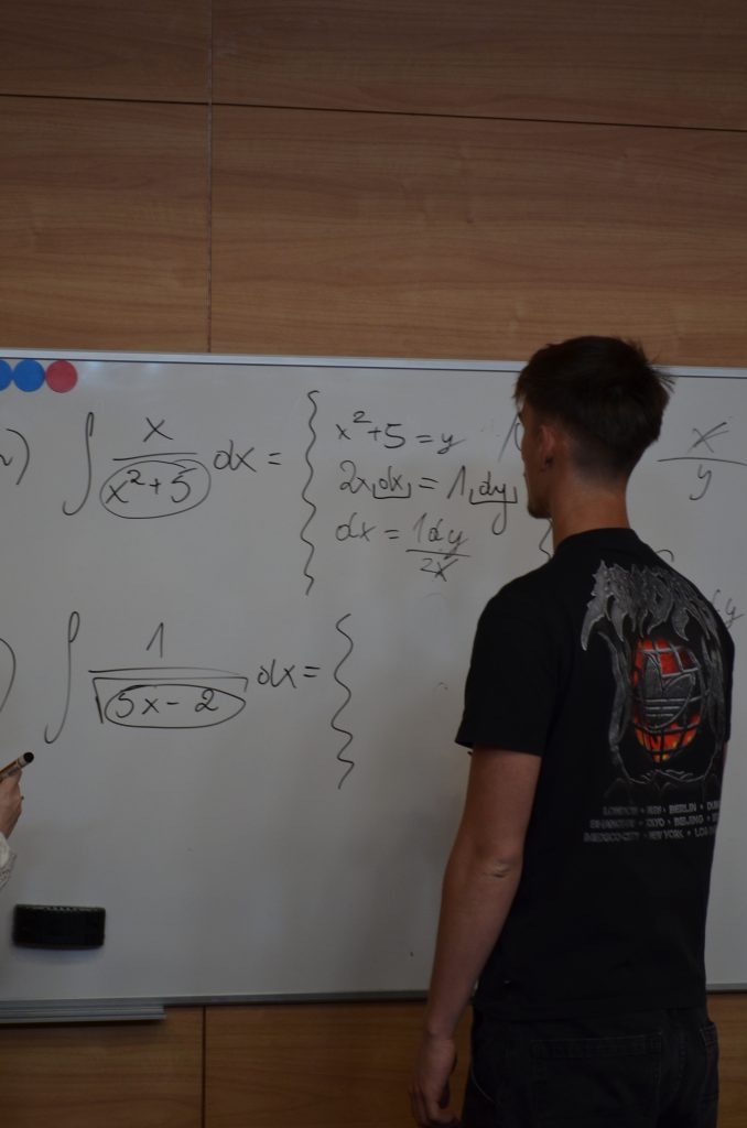 uczeń LO przy tablicy rozwiązujący zadania z matematyki